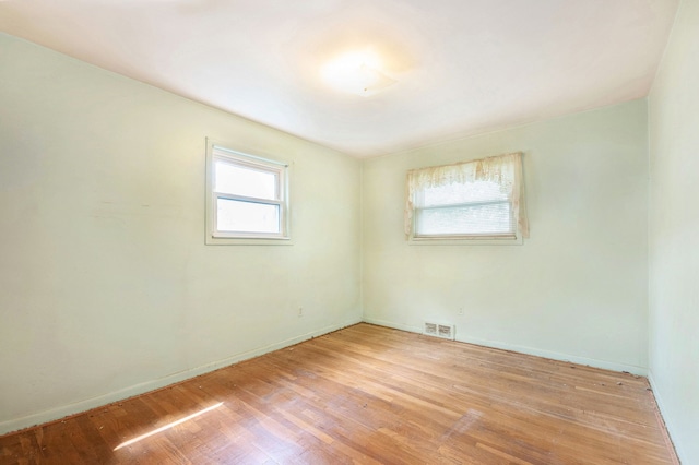 unfurnished room with light wood-style flooring and baseboards