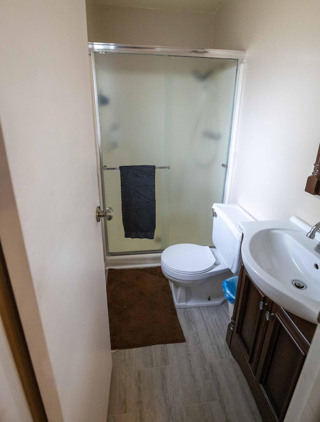 1291 103rd Ave, Plainwell, MI 49080 - bathroom featuring a stall shower, vanity, wood finished floors, and toilet