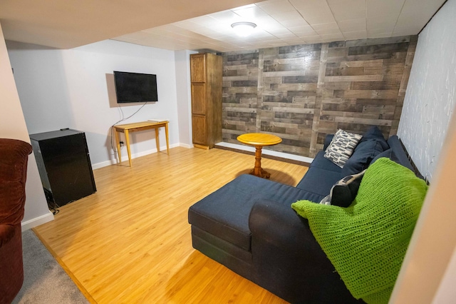1291 103rd Ave, Plainwell, MI 49080 - living room featuring wood finished floors, an accent wall, wood walls, and baseboards