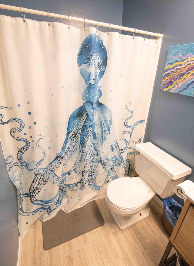 1291 103rd Ave, Plainwell, MI 49080 - full bath featuring toilet, a shower with curtain, and wood finished floors