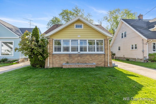 view of front of home featuring brick siding and a front yard