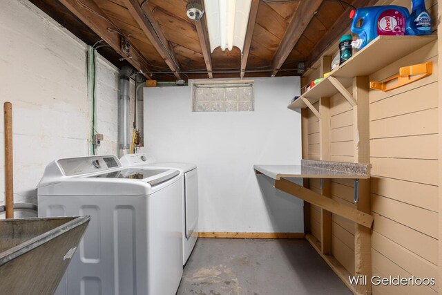 washroom with washing machine and dryer and baseboards