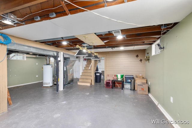below grade area featuring water heater, heating unit, stairway, and healthy amount of natural light