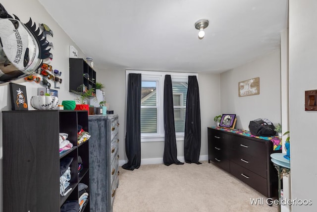 bedroom featuring light carpet and baseboards