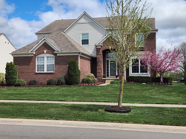traditional home featuring brick siding and a front yard