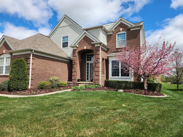 traditional-style home featuring brick siding, a front yard, and roof with shingles