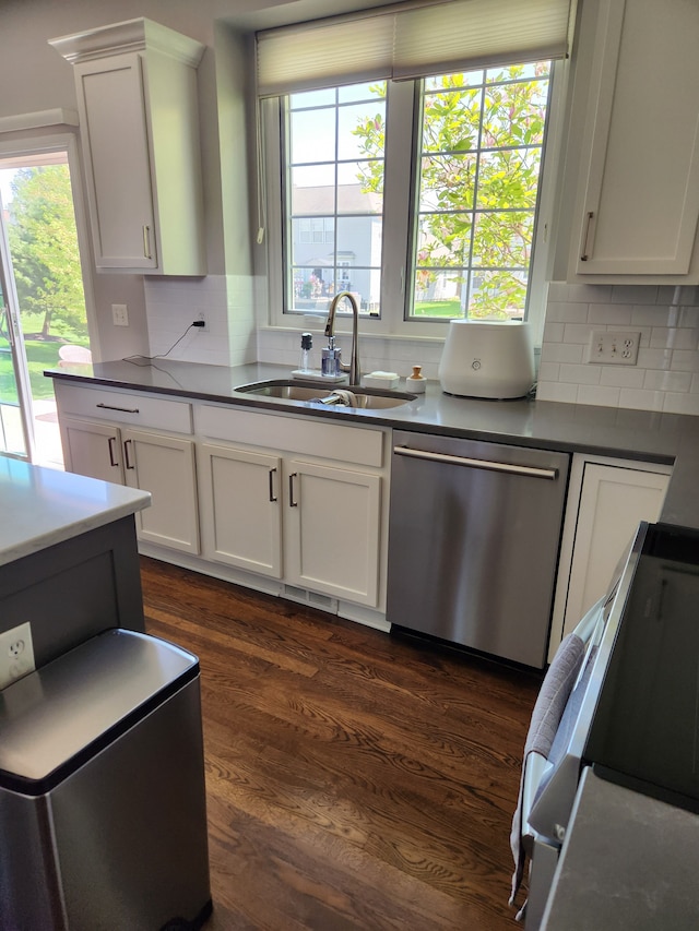 kitchen featuring stainless steel dishwasher, a sink, electric range, decorative backsplash, and dark countertops
