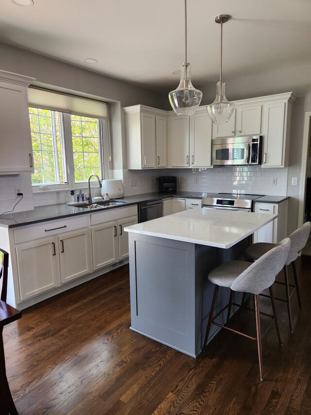 kitchen with stainless steel appliances, a sink, tasteful backsplash, white cabinetry, and recessed lighting