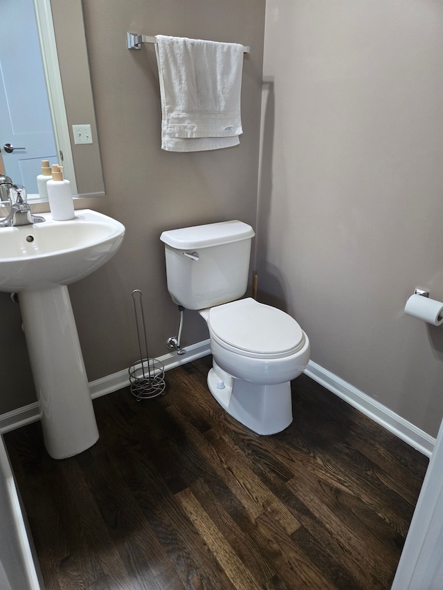 bathroom with wood finished floors, toilet, and baseboards
