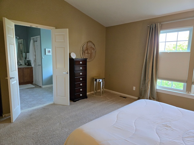 bedroom with carpet floors, lofted ceiling, and baseboards