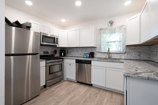 2170 Sonoma St, Ferndale, MI 48220 - kitchen with stainless steel appliances, a sink, light wood finished floors, backsplash, and recessed lighting