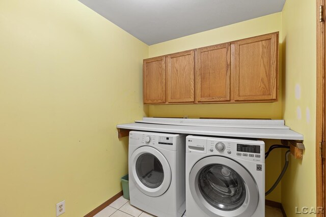 11160 W Ridgeville Rd, Morenci, MI 49256 - washroom featuring cabinet space, washing machine and dryer, light tile patterned flooring, and baseboards