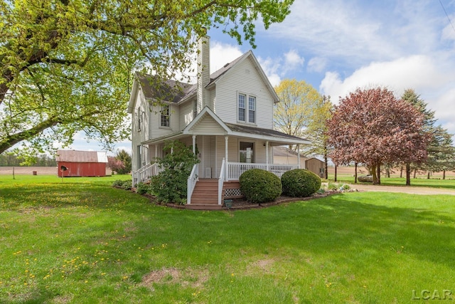 11160 W Ridgeville Rd, Morenci, MI 49256 - farmhouse featuring a shed, a chimney, covered porch, an outbuilding, and a front yard