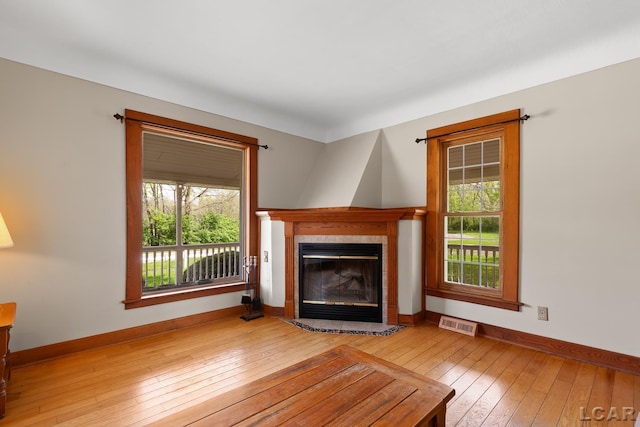 11160 W Ridgeville Rd, Morenci, MI 49256 - unfurnished living room with a tiled fireplace, hardwood / wood-style flooring, and baseboards
