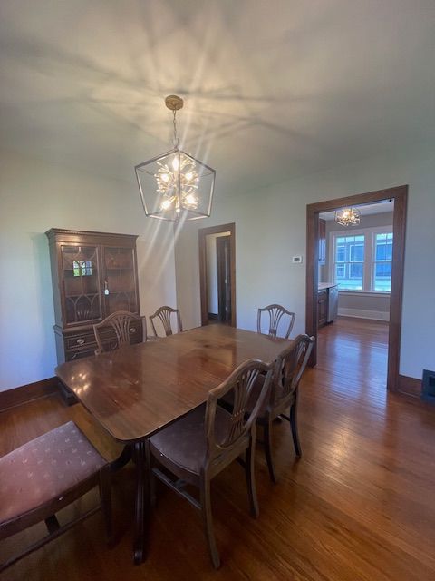 dining room with a chandelier, wood finished floors, and baseboards