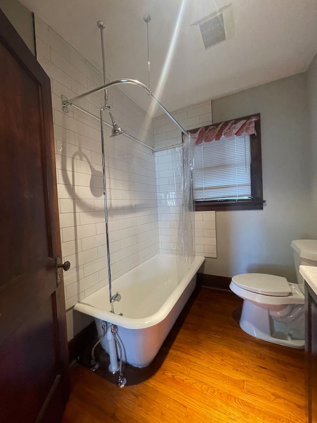 full bath featuring wood finished floors, toilet, shower / bath combination, and vanity