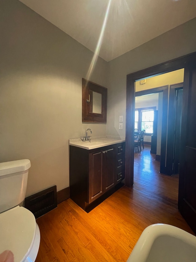 bathroom with wood finished floors, toilet, baseboards, and vanity