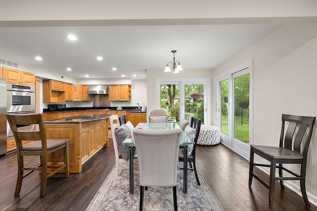 dining area featuring dark wood finished floors, a chandelier, recessed lighting, and baseboards