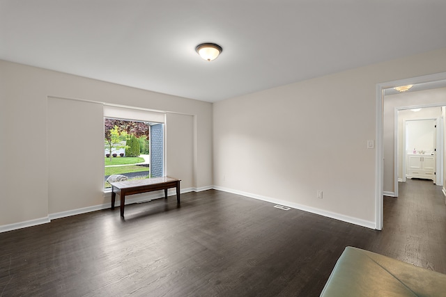 unfurnished room with dark wood-type flooring and baseboards
