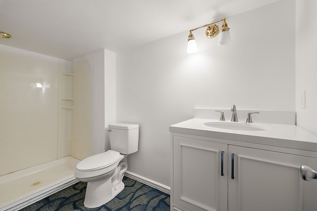 bathroom featuring toilet, a shower, and vanity