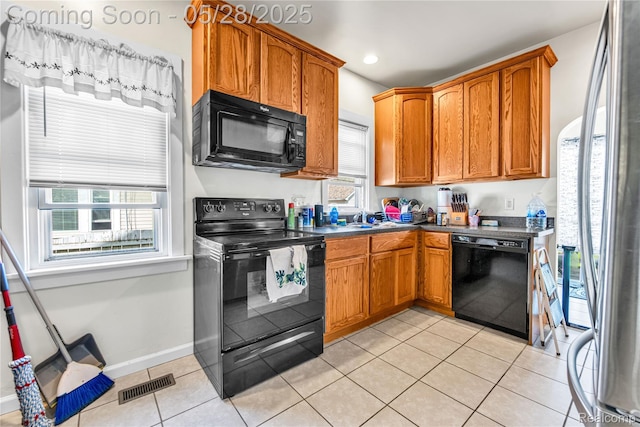 414 Riverview Ave, Monroe, MI 48162 - kitchen featuring black appliances, dark countertops, light tile patterned floors, brown cabinetry, and recessed lighting