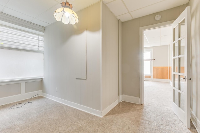 empty room with light carpet and a paneled ceiling