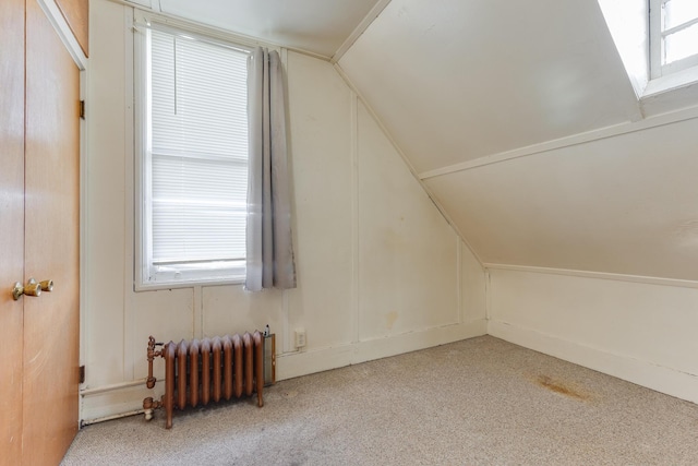 additional living space with radiator heating unit, carpet, and lofted ceiling