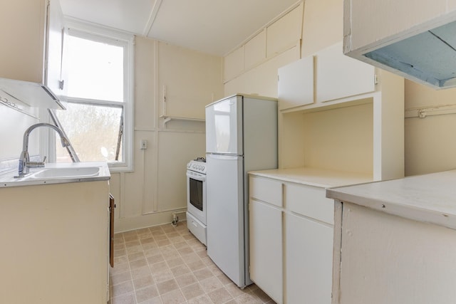 kitchen with a sink, white appliances, and light countertops