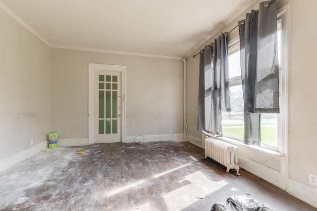 spare room with radiator, healthy amount of natural light, crown molding, and baseboards