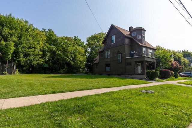 view of side of home featuring a lawn and a chimney