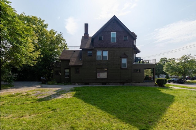 view of home's exterior with a chimney and a yard