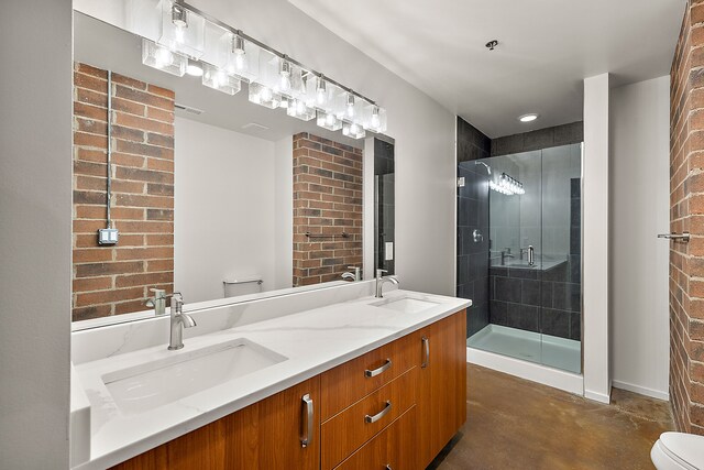 full bathroom featuring toilet, concrete flooring, a stall shower, brick wall, and double vanity