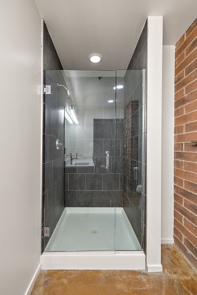 full bathroom with baseboards, a shower stall, and concrete flooring