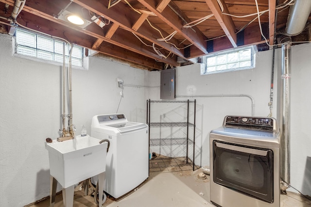laundry room featuring electric panel and washer and clothes dryer