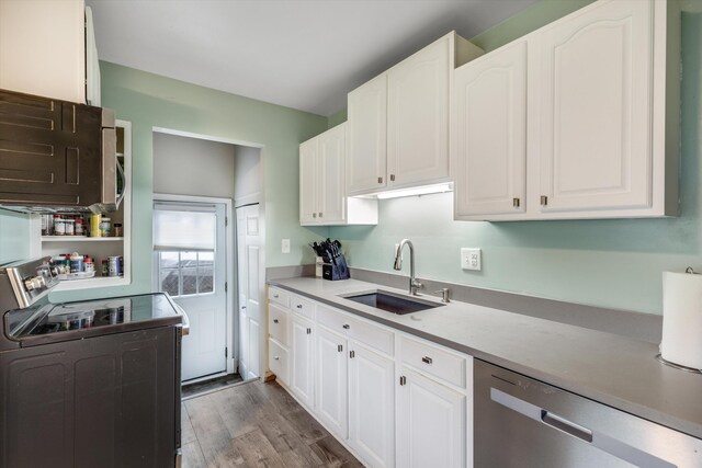 kitchen with a sink, dishwasher, electric range, and white cabinetry