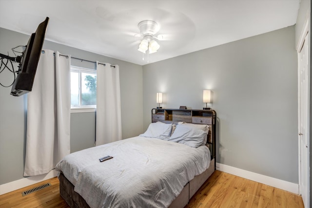 bedroom featuring baseboards, light wood-style floors, and ceiling fan