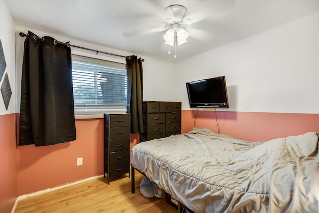 bedroom featuring light wood-type flooring, baseboards, and a ceiling fan