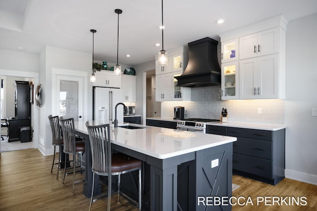 4497 Point Superior Ct, Holland, MI 49424 - kitchen with custom exhaust hood, a sink, high quality appliances, baseboards, and tasteful backsplash