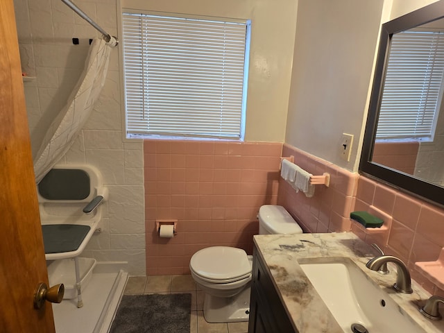 full bath with tile walls, curtained shower, toilet, tile patterned flooring, and vanity