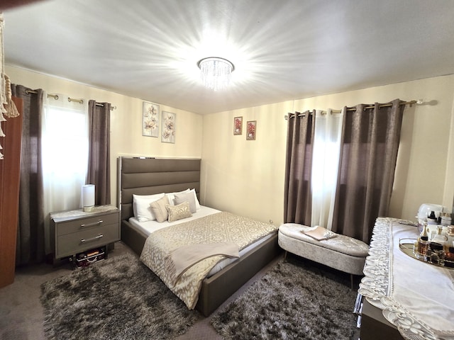 bedroom with a chandelier and dark carpet