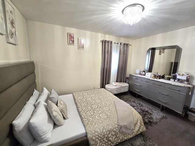 bedroom featuring dark carpet and a chandelier