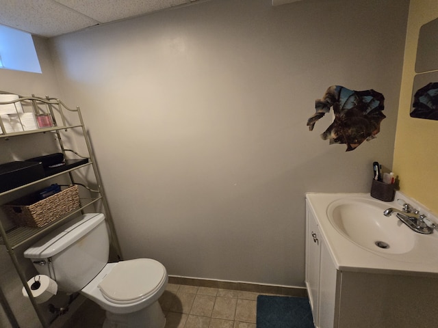 bathroom with toilet, vanity, tile patterned floors, and baseboards