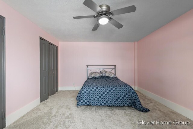bedroom with carpet flooring, ceiling fan, a textured ceiling, baseboards, and a closet