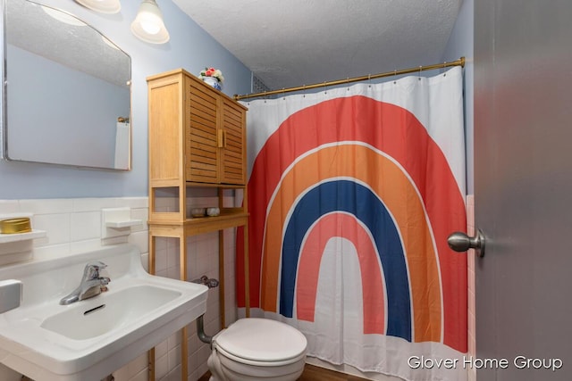 full bathroom featuring a sink, a textured ceiling, and toilet