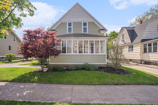 view of front of house featuring a front yard and a shingled roof