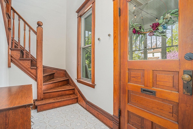 entrance foyer featuring stairs and baseboards