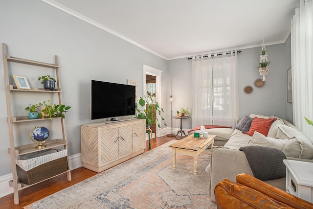living room featuring wood finished floors, ornamental molding, and baseboards