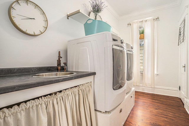 washroom with ornamental molding, dark wood-type flooring, and washing machine and clothes dryer