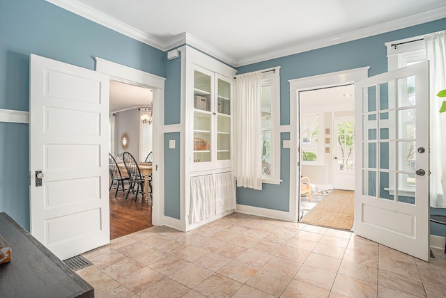 foyer with crown molding, baseboards, and a chandelier