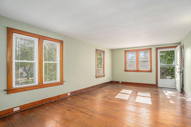 spare room with hardwood / wood-style flooring and baseboards